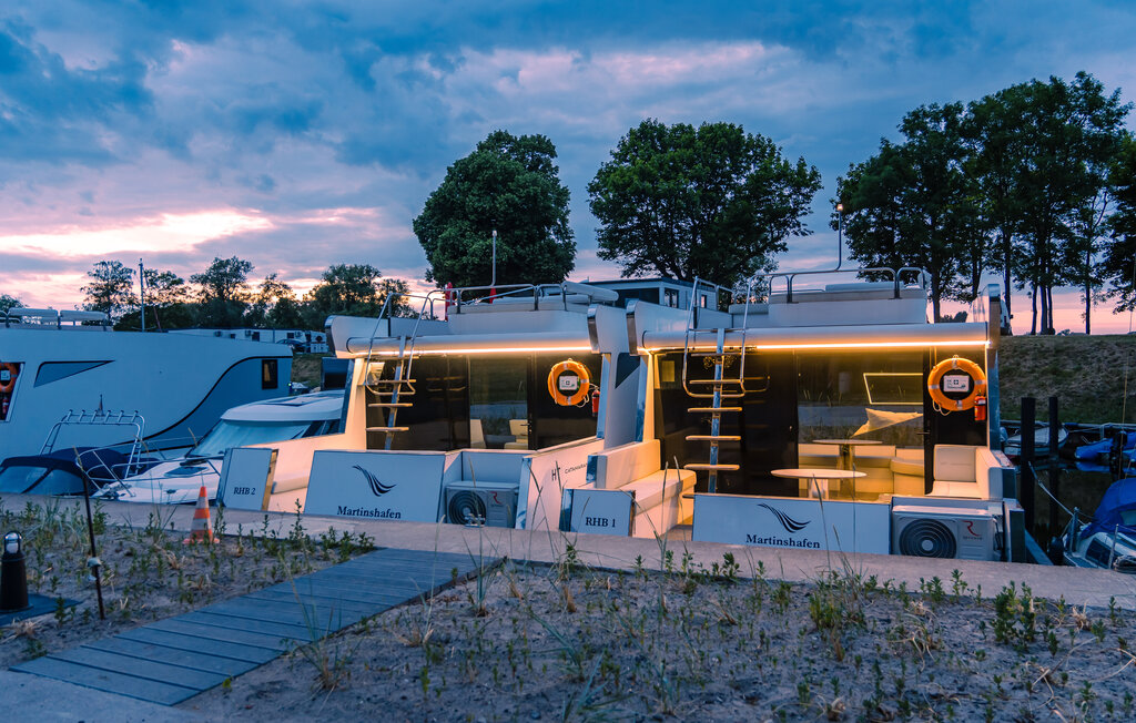 Das festliegende Hausboot Relax verbindet eindrucksvoll Luxus auf dem Wasser mit der Nähe zur Natur in der Marina Martinshafen. 

Sie betreten die Wassersuite über eine Terrasse mit Loungesitzmöbel..