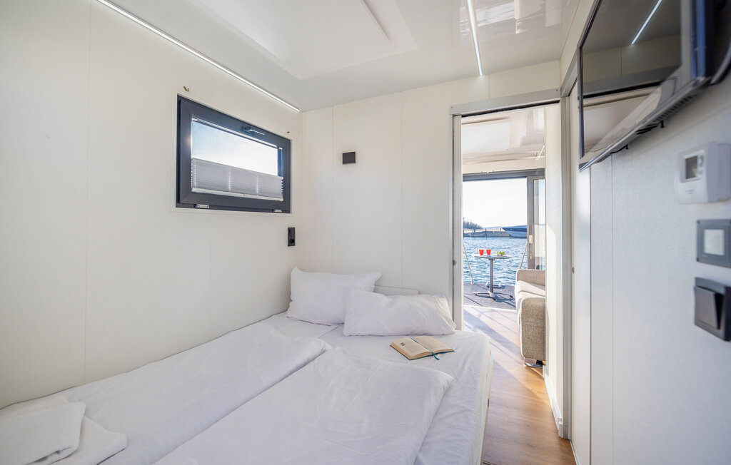 Das Tiny-Hausboot, als Mobilheim auf dem Wasser, verfügt über einen kleinen Wohnbereich mit Schlafcouch und Flachbild-SAT-TV. Ein kleines separates Schlafzimmer verfügt über ein ausziehbares Bett...