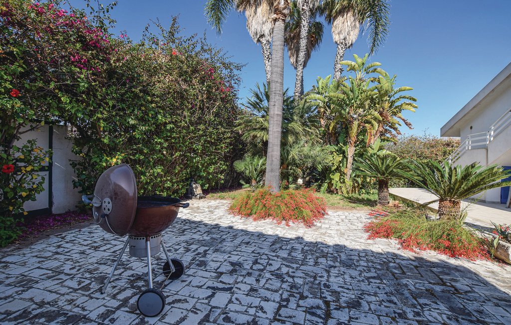 Dieses elegante Ferienhaus in einem Wohngebiet von Marina di Ragusa liegt 400 m vom Meer entfernt und bietet einen großen privaten Pool. Das Anwesen empfängt Sie mit einem gepflegten Rasen mit Blume..