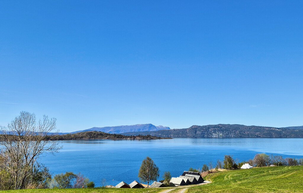 Dit gastvrije vakantiehuis heeft een prachtige ligging met uitzicht op de fjord en biedt lichte, ontspannen ruimtes om samen tijd door te brengen. In de belangrijkste woonruimte omlijsten brede ramen ..