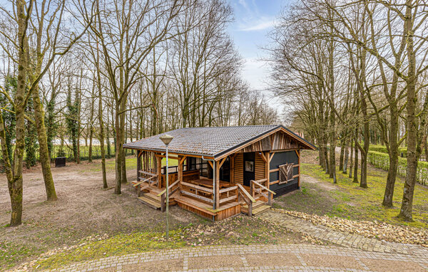 Diese einladende Unterkunft in Erm in den Niederlanden vermittelt ein behagliches, ungezwungenes Ambiente. Ein heller Essbereich neben großen Glastüren blickt auf eine von Bäumen gesäumte Terrasse..